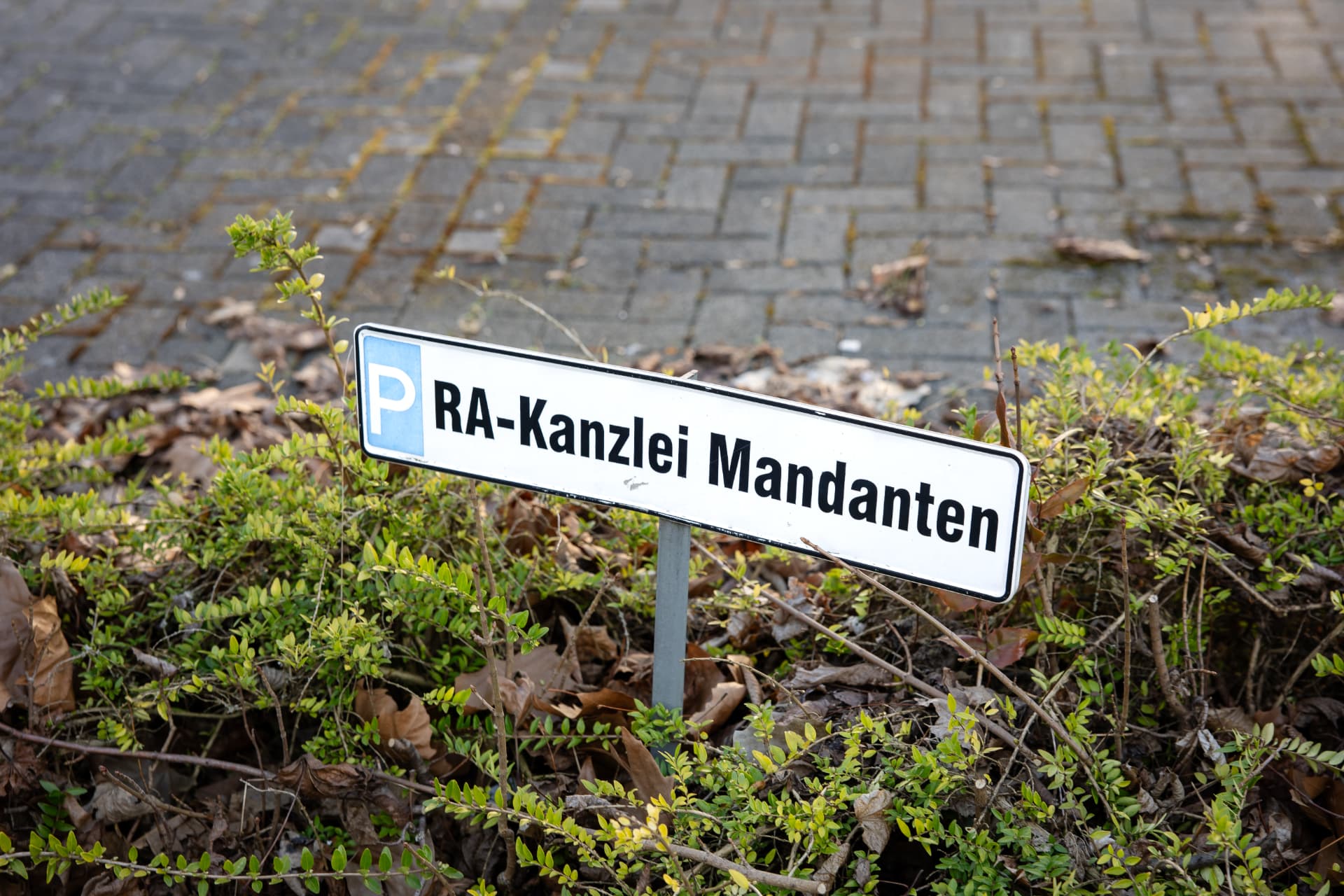 Schild mit der Aufschrift „P RA-Kanzlei Mandanten“ vor dem Kanzleigebäude